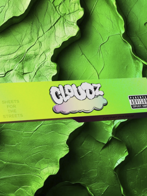 Box of Cloudz hemp paper with a cloud logo on a bright yellow-green gradient, laid over large green leaves background