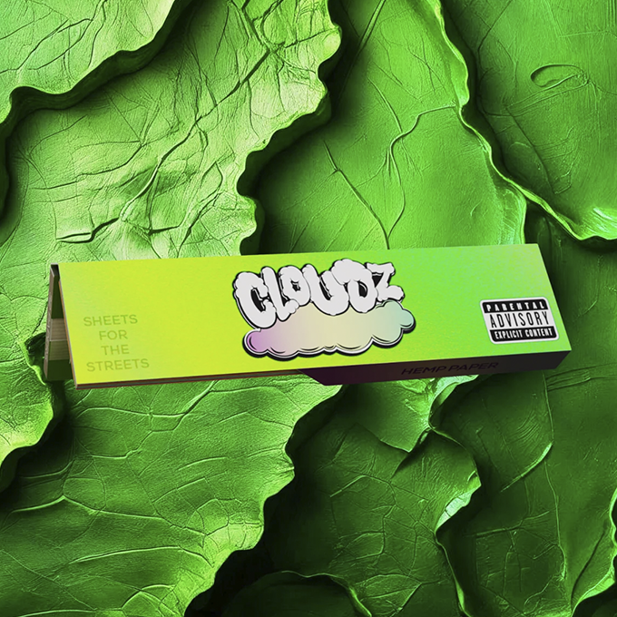 Box of Cloudz hemp paper with a cloud logo on a bright yellow-green gradient, laid over large green leaves background