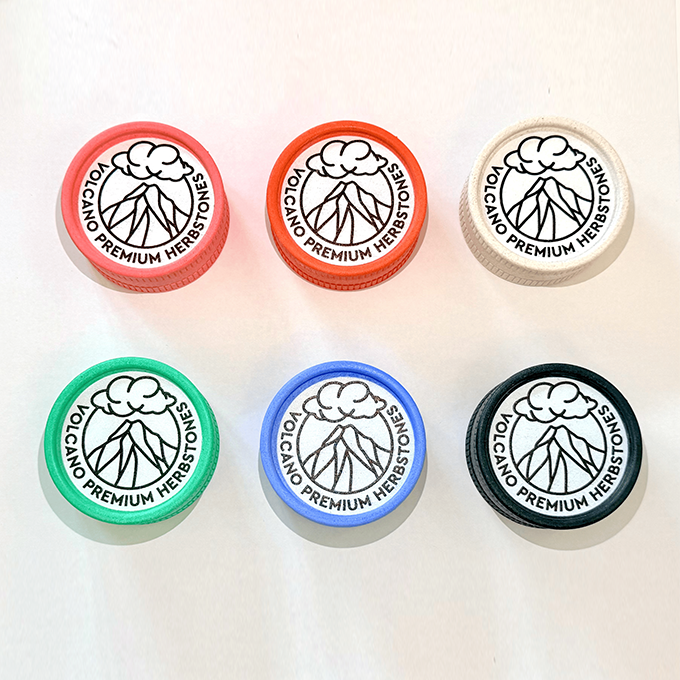 Six color caps arranged in two rows, each with a volcano logo and the text VOLCANO PREMIUM HERBSTONES.