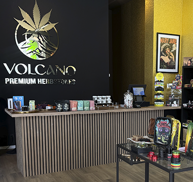 Volcano-Shop-München-Maxvorstadt-small Store interior of Volcano Premium Hemp Botanicals with a long wooden counter and hemp products on display on the shelves behind it.